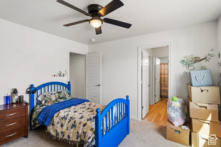 White walls, ceiling fan with integrated lighting, wood-finish flooring, and painted interior doors