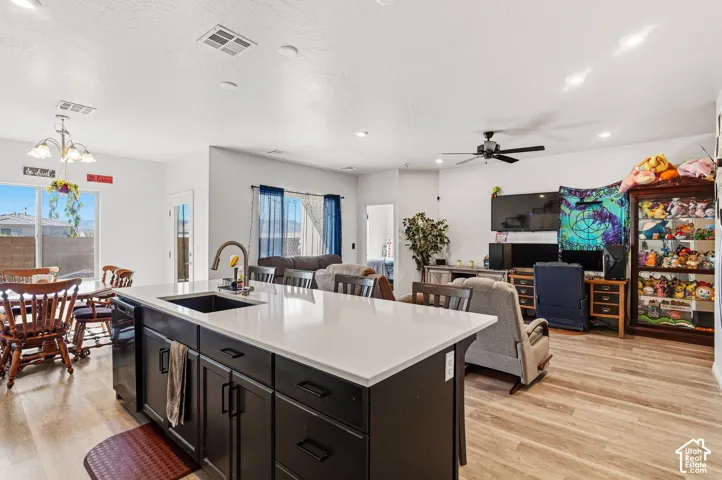 Spacious kitchen island with a white countertop and dark cabinetry, featuring an integrated sink with a gooseneck faucet