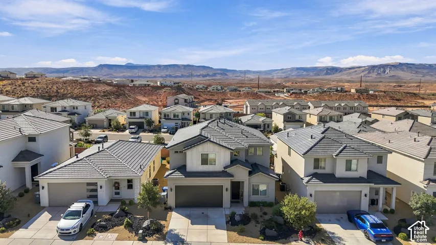 Contemporary residential architecture with a neutral color palette, featuring a tiled roof and integrated garages