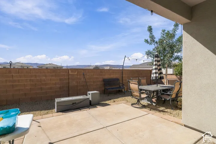 Paved patio area with a partial overhang, gravel landscaping, and a block privacy wall