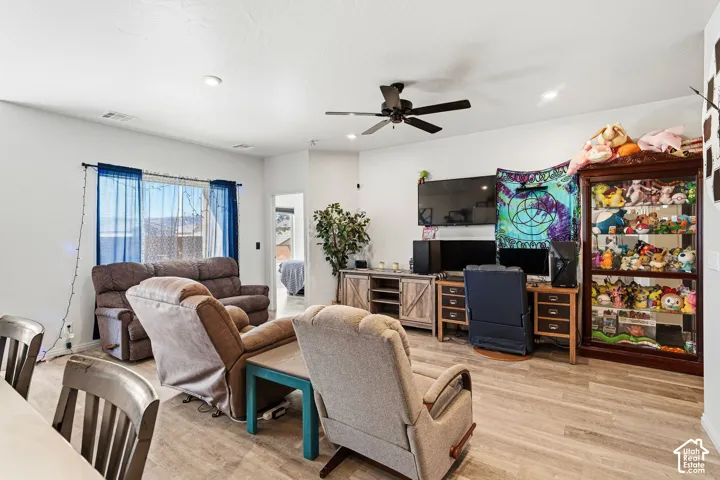 Recessed ceiling lighting, wood-finish flooring, ceiling fan with light fixture, and window with natural light