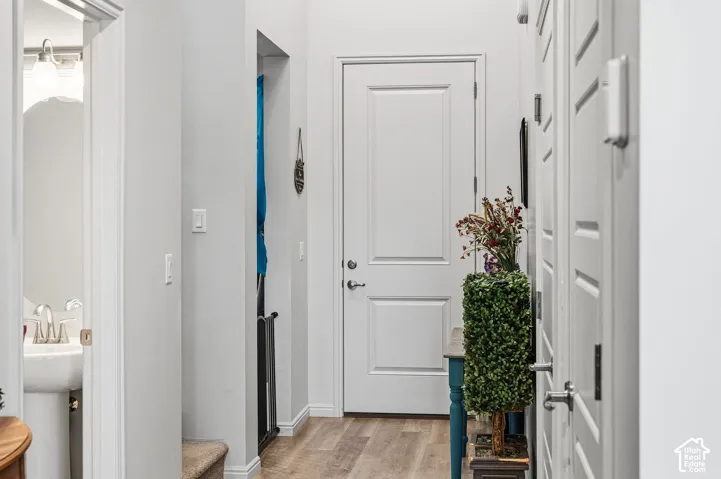 Wood-finish flooring, white paneled doors, and light gray walls
