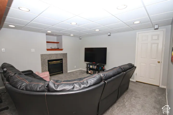Recessed lighting, drop ceiling, and a fireplace with a stone surround