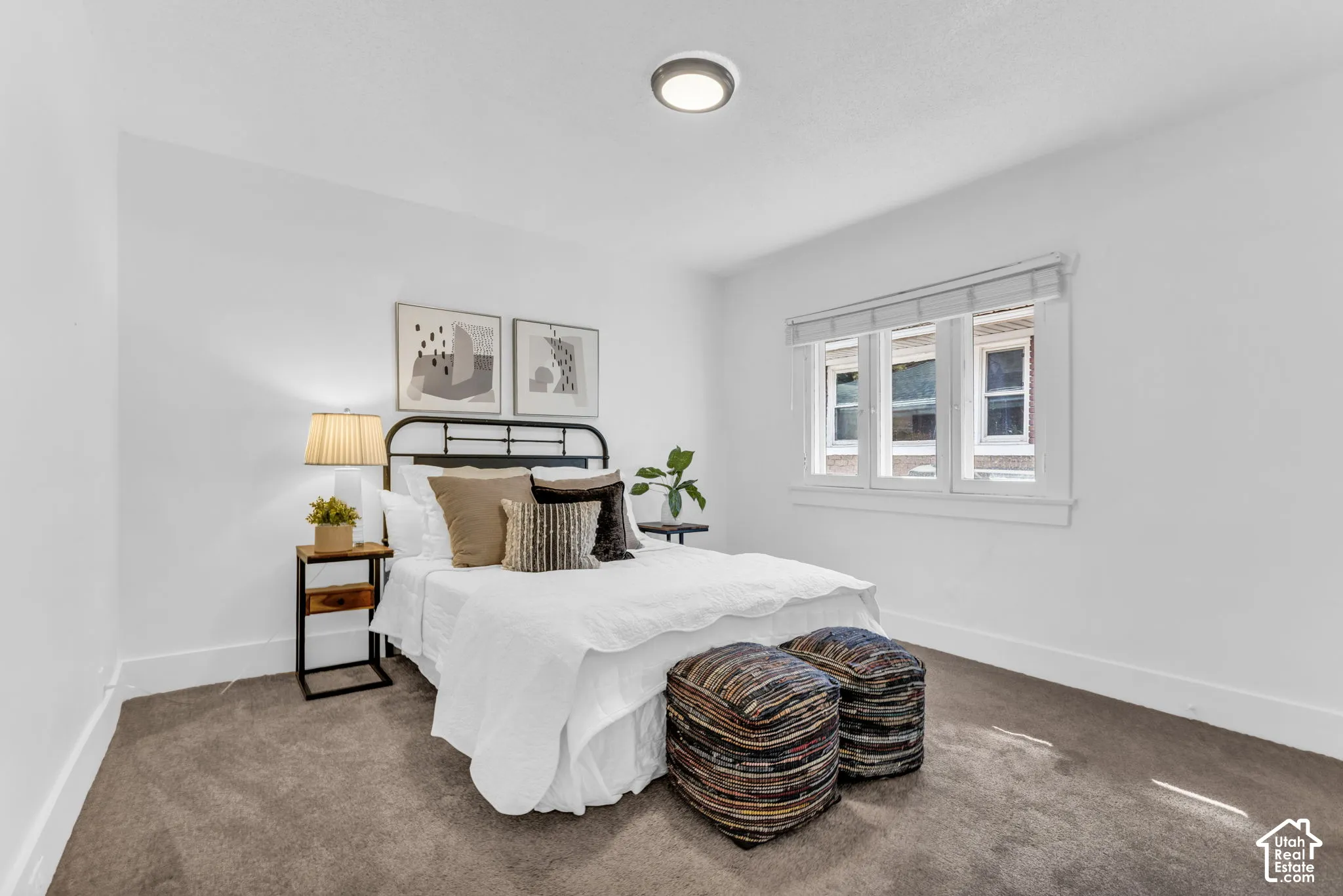 Recessed ceiling light, neutral wall colors, three-pane window with blinds, and carpeted flooring