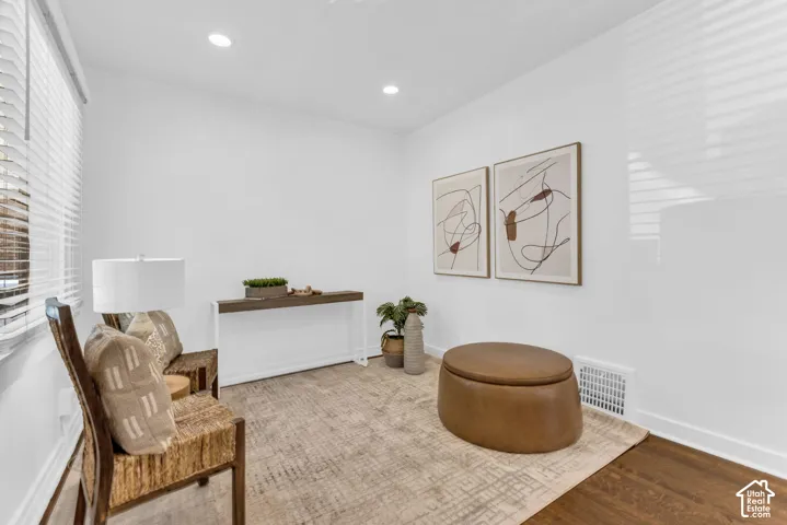 Recessed lighting illuminates wood-finish flooring
