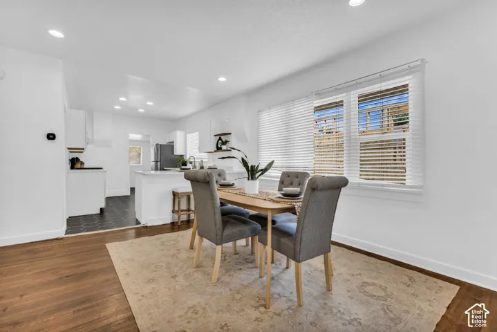 Dining area with wood-finish flooring, recessed lighting, and a window with blinds