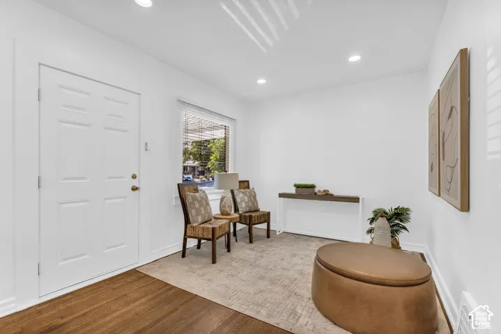 Wood-finish flooring, recessed lighting, and a white paneled entry door