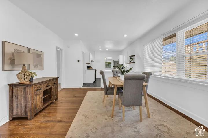 Hardwood-style flooring throughout, recessed lighting, and a bright kitchen with white cabinetry