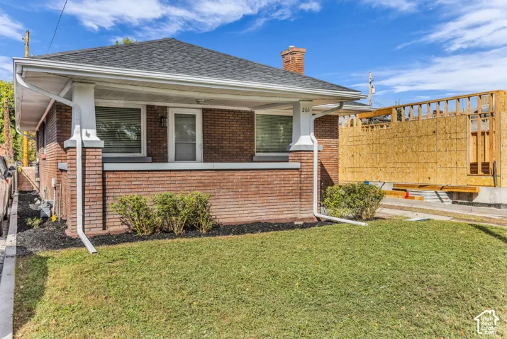 Brick exterior with a covered porch, white columns, and a dark shingle roof