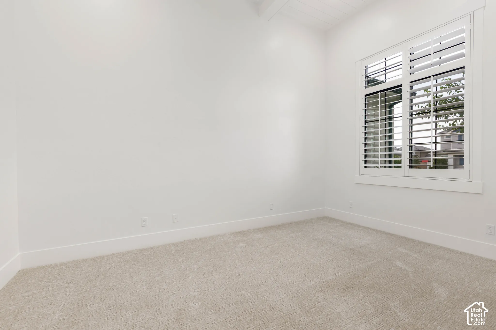 Light-toned carpeting and white walls with white baseboards