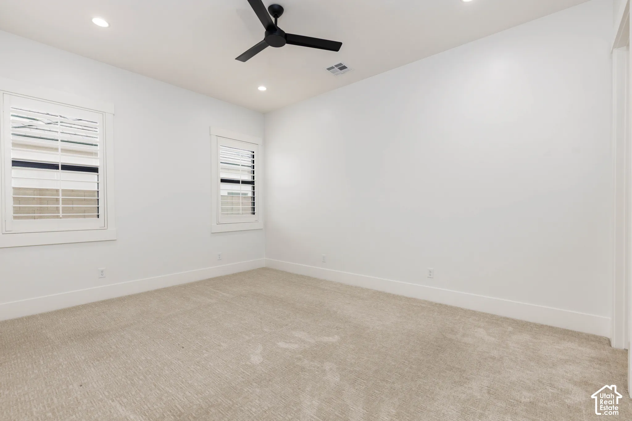 Recessed lighting, a ceiling fan, and carpeted flooring