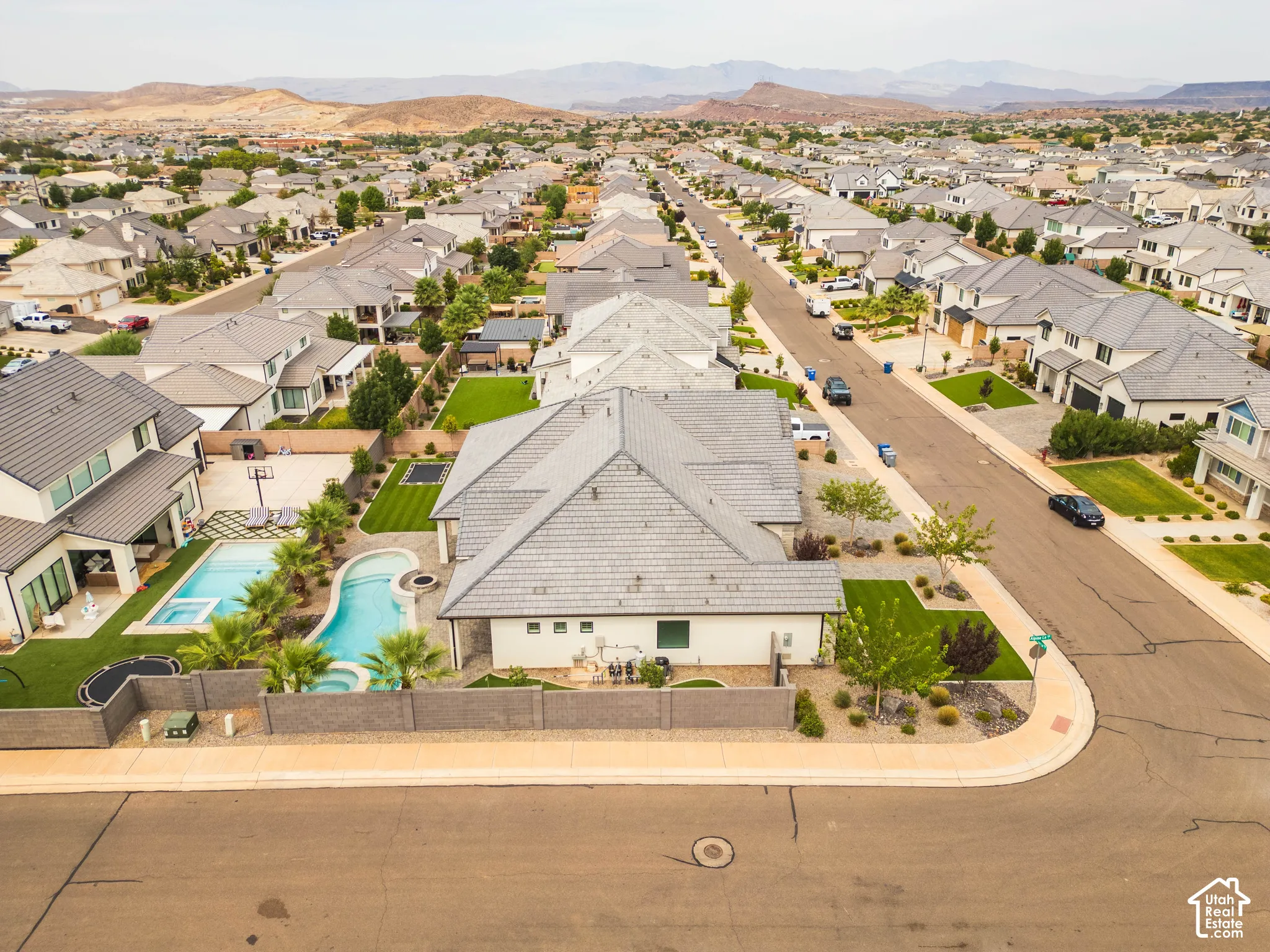Modern residential street with mature landscaping and mountain scenery