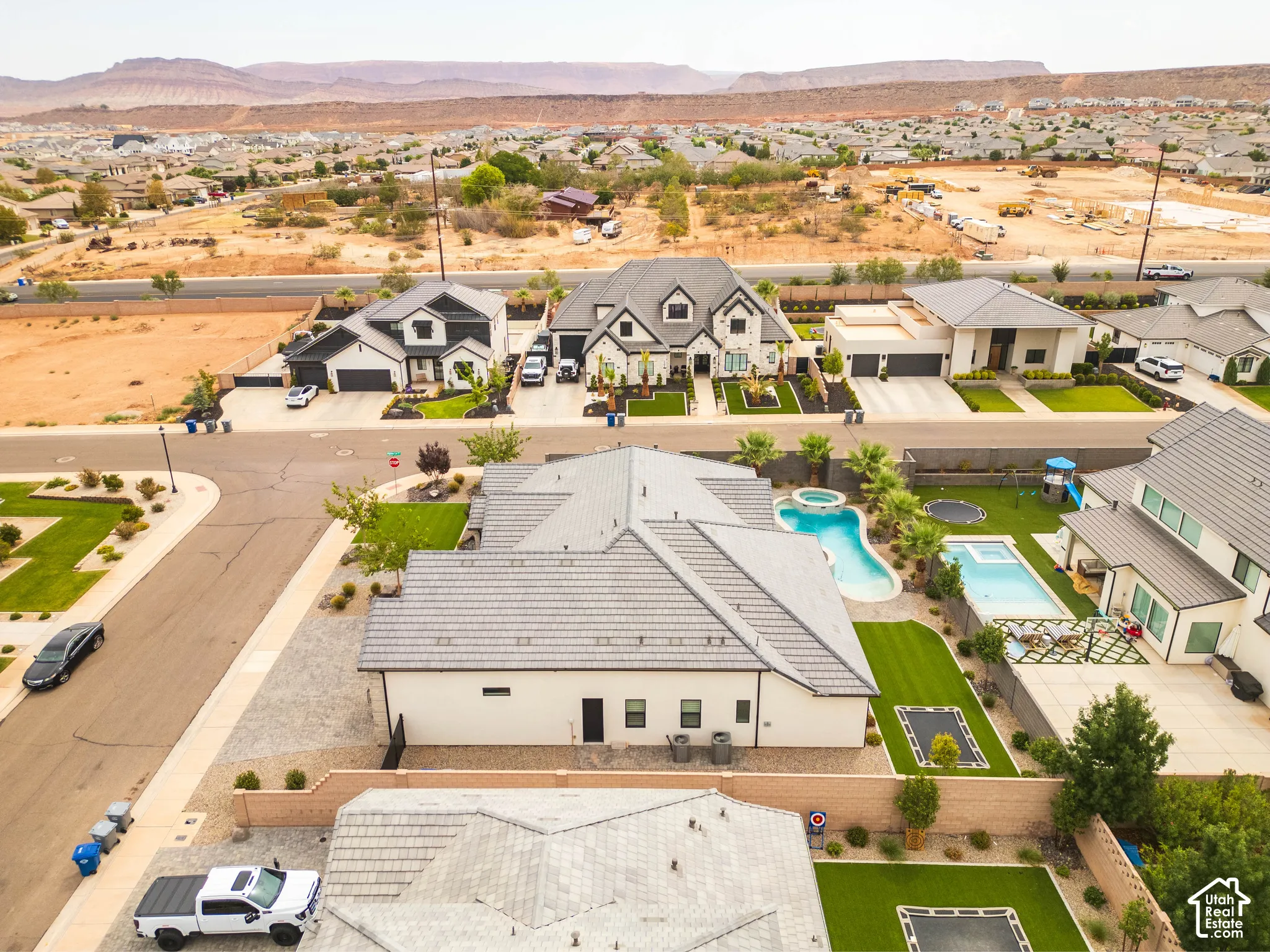 Manicured backyard with two swimming pools, a spa, and artificial turf sections