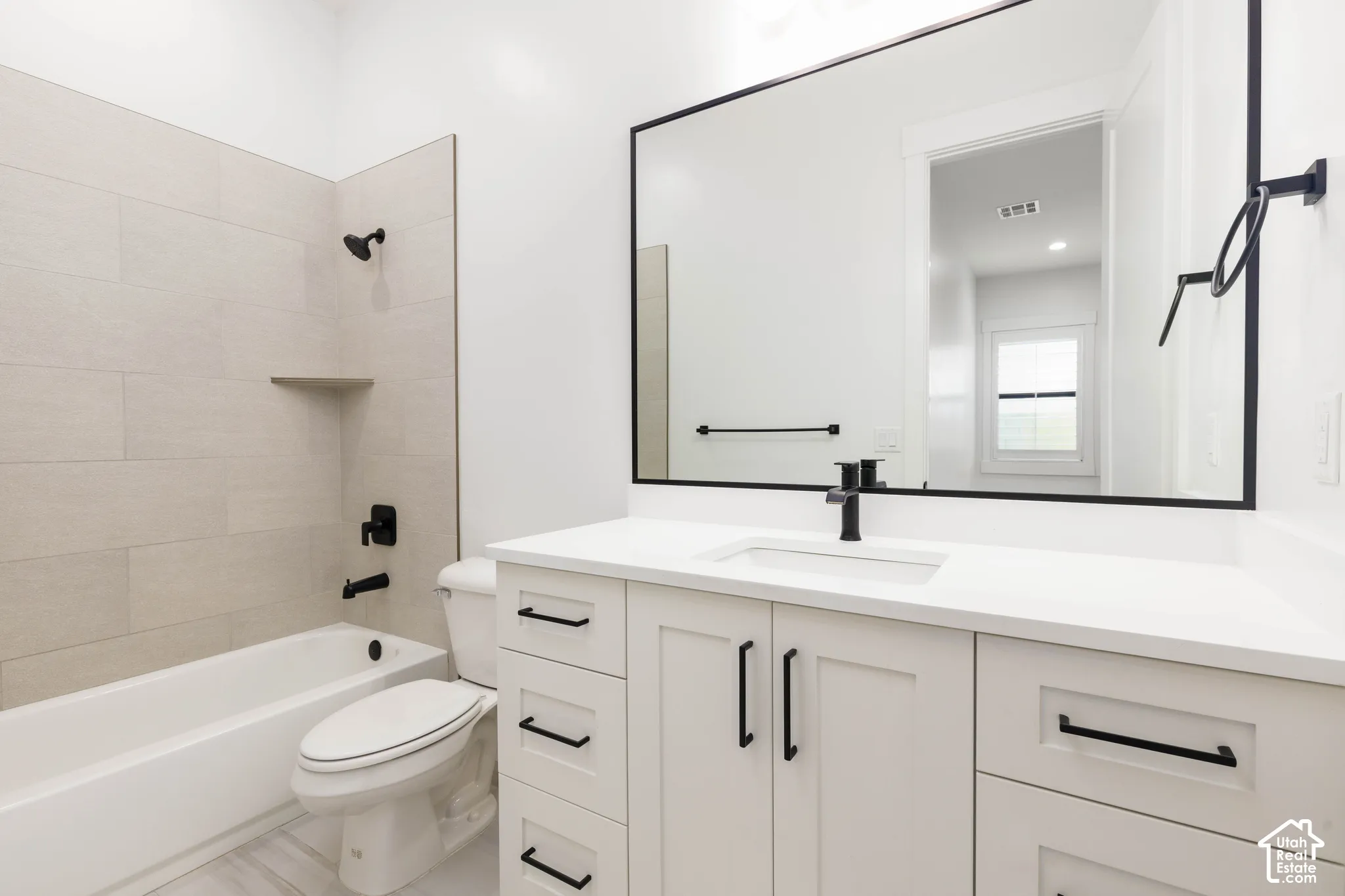 White vanity with a rectangular undermount sink and matte black faucet