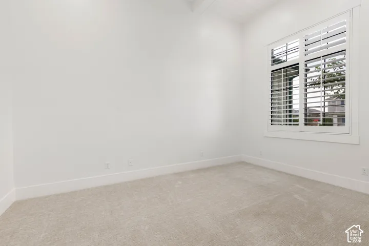 Light-toned carpeting and white walls with white baseboards
