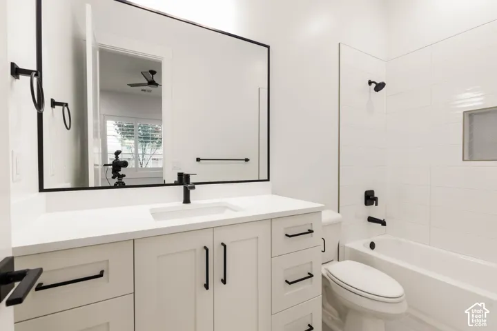 White vanity with shaker-style cabinetry, matte black hardware, integrated sink, and a large framed mirror