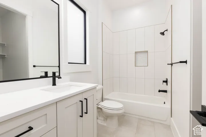 White vanity with shaker-style cabinetry, matte black hardware, and integrated sink