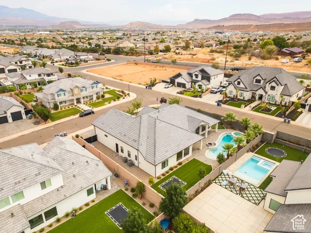 Expansive backyard featuring a custom-shaped swimming pool, integrated spa, and artificial turf lawn