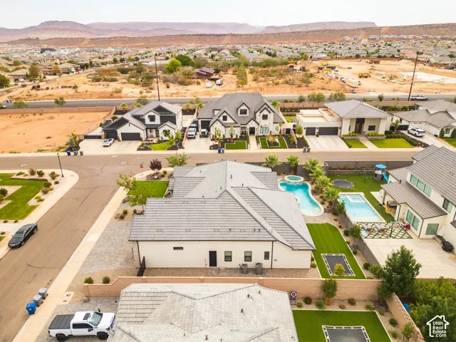 Manicured backyard with two swimming pools, a spa, and artificial turf sections