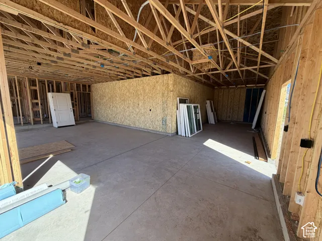 Exposed wood framing, concrete flooring, and an open ceiling
