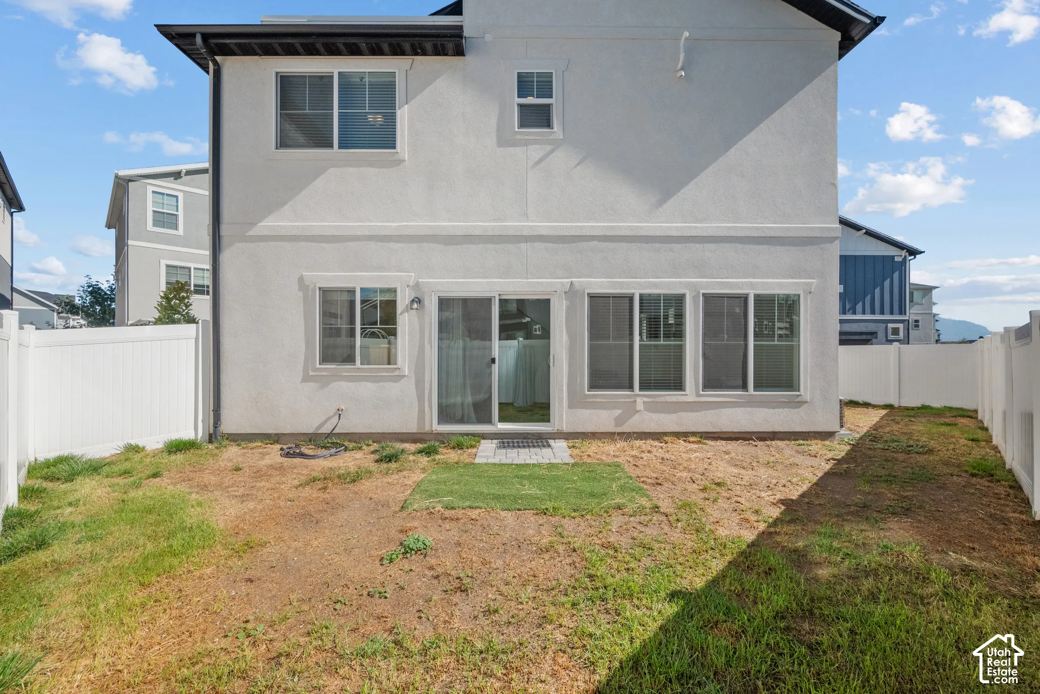 White stucco exterior with a dark roof and white trim