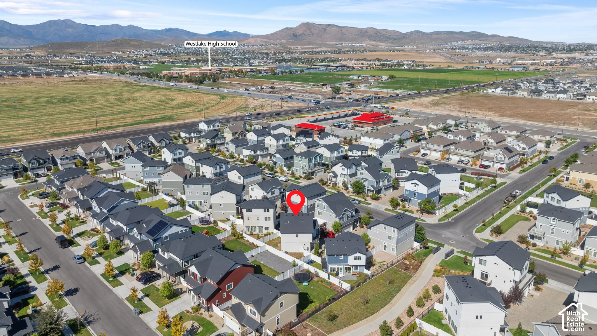 Aerial perspective showcasing a residential development with surrounding open fields and distant mountains