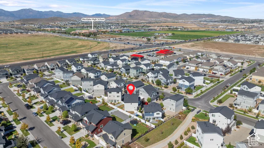 Aerial perspective showcasing a residential development with surrounding open fields and distant mountains
