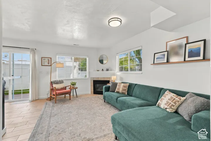 Gas fireplace with wood-finish tile flooring, sliding glass patio door, and plenty of natural light