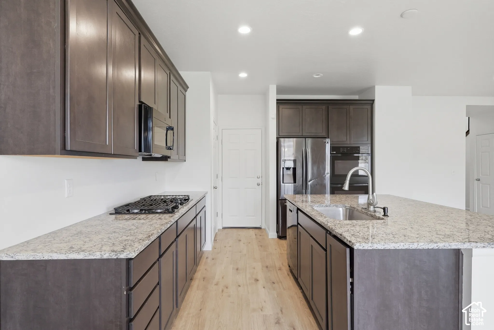 Wood-finish flooring, recessed lighting, and dark wood cabinetry