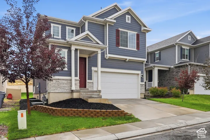 Two-story residence featuring blue siding, white trim, and a prominent front-facing garage