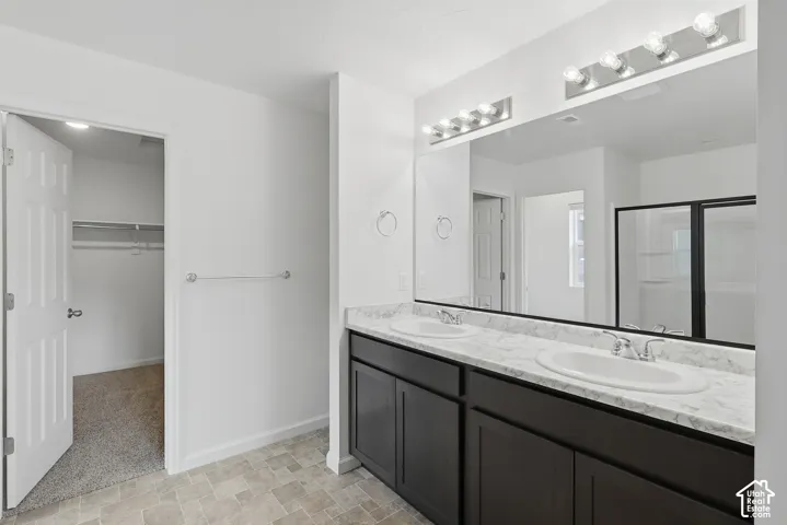Dual vanity with undermount sinks, spacious mirror, and dark cabinetry