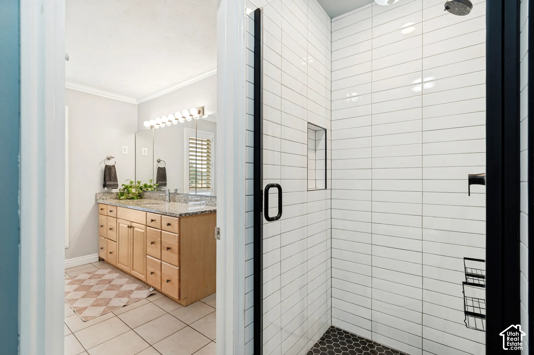 Walk-in shower with white subway tile surround and black hexagon mosaic tile floor
