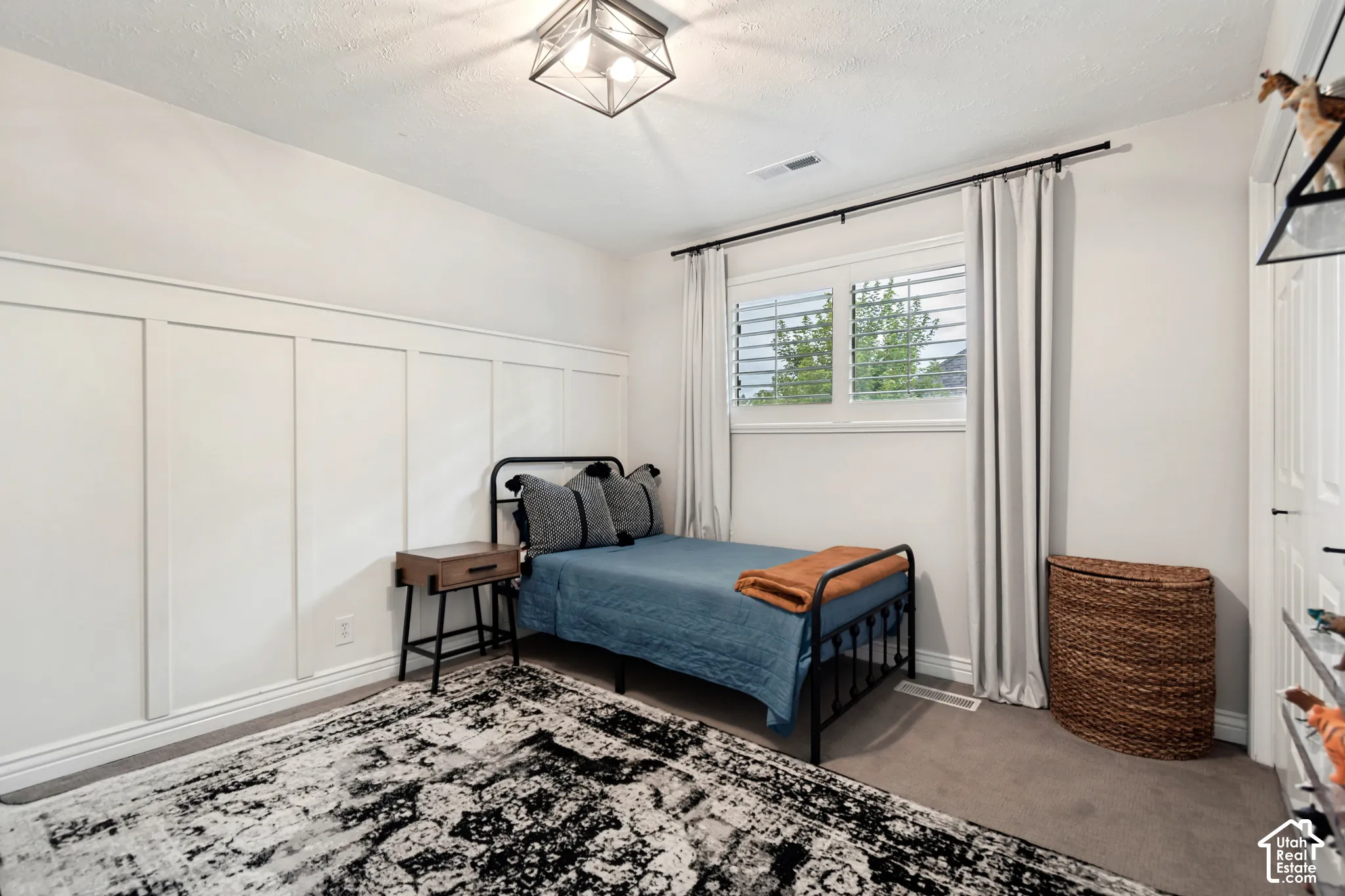 Board and batten accent wall, recessed window with louvered shutters, ceiling-mounted light fixture, and carpeting