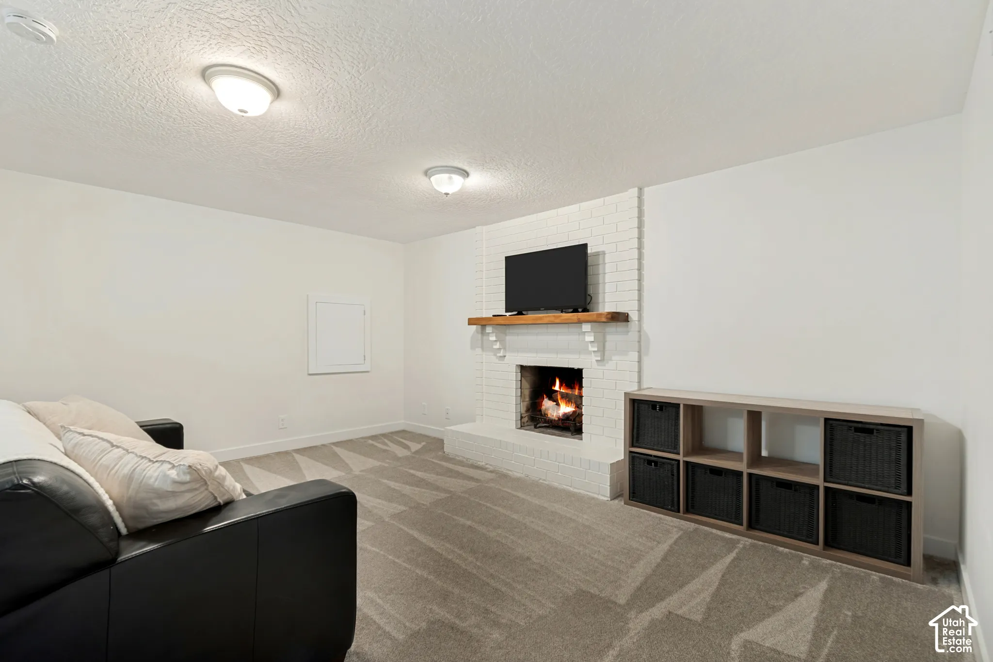 White brick fireplace with a wood mantel