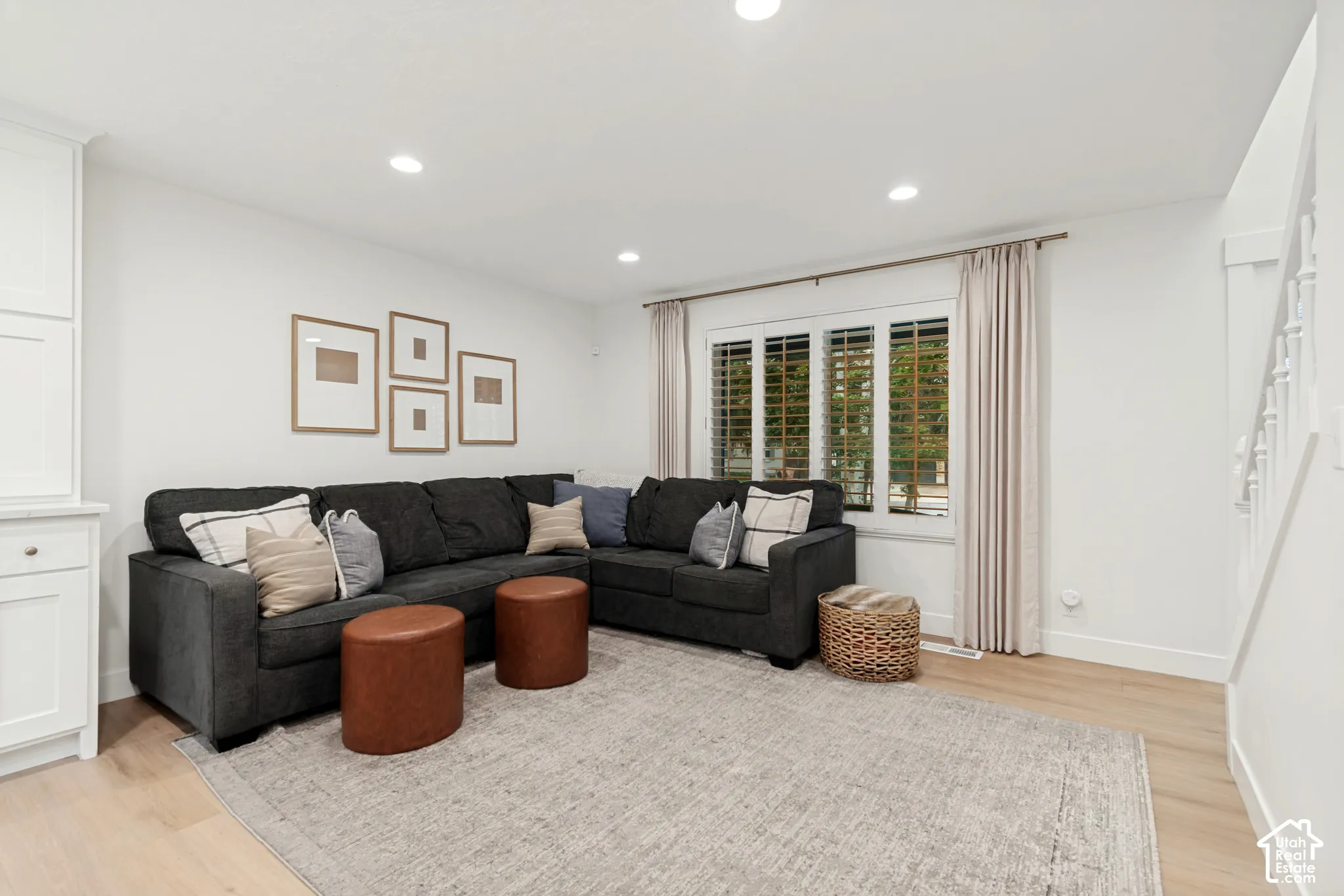 Recessed lighting, light wood-finish flooring, white built-in cabinetry, white window shutters, and white wall finishes
