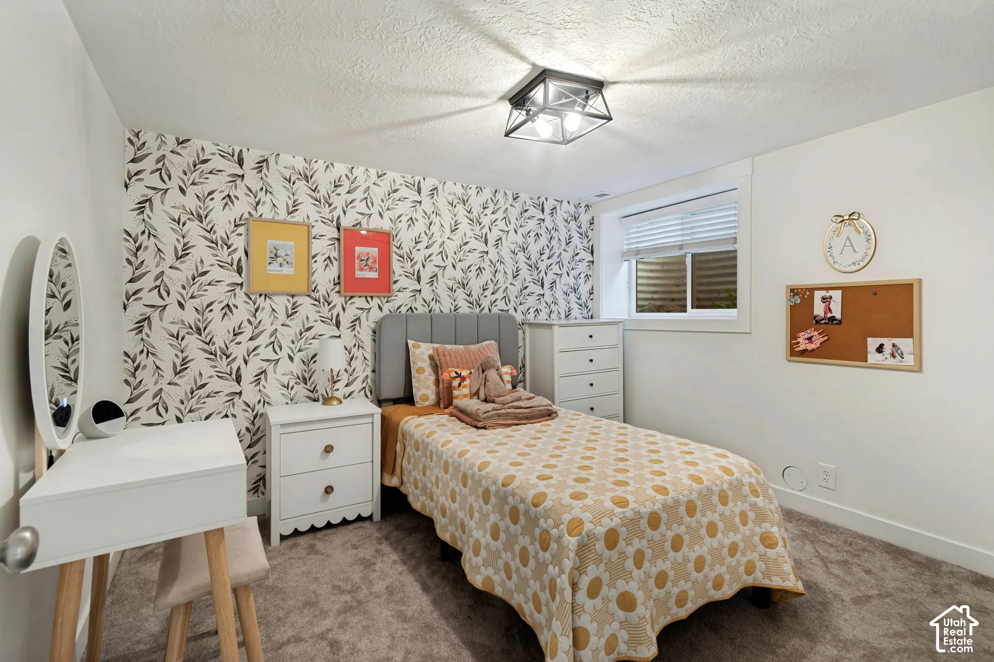 Accent wall with botanical print, window with blinds, ceiling-mounted light fixture, and carpeted flooring