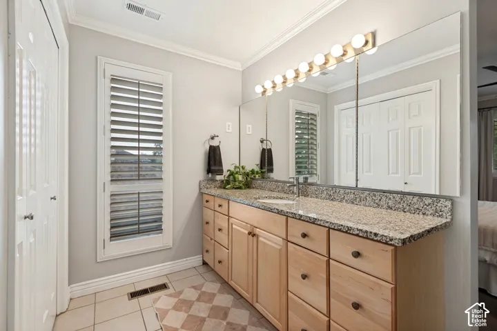 Double vanity with granite-style countertop, wood-finish cabinetry, and integrated sinks