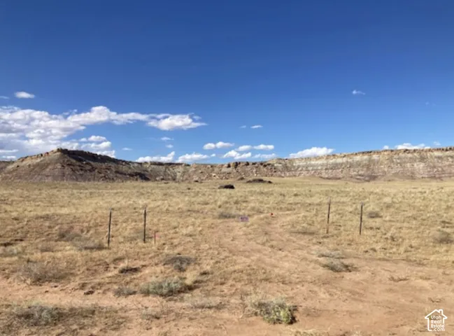 Expansive land parcel featuring natural topography, sparse vegetation, and distant bluffs