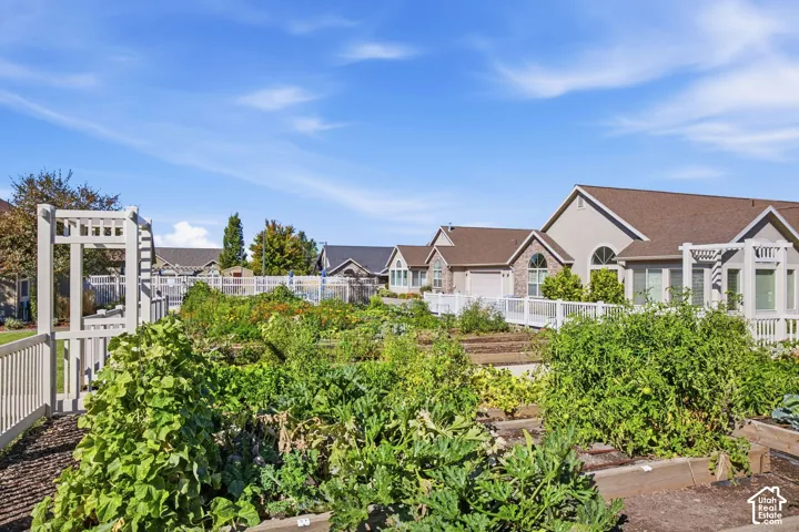 Community garden plots with an arbor entrance and white fencing