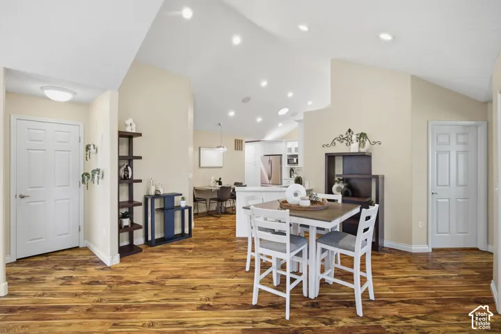 Vaulted ceilings with recessed lighting, wood-finish flooring, and white paneled interior doors