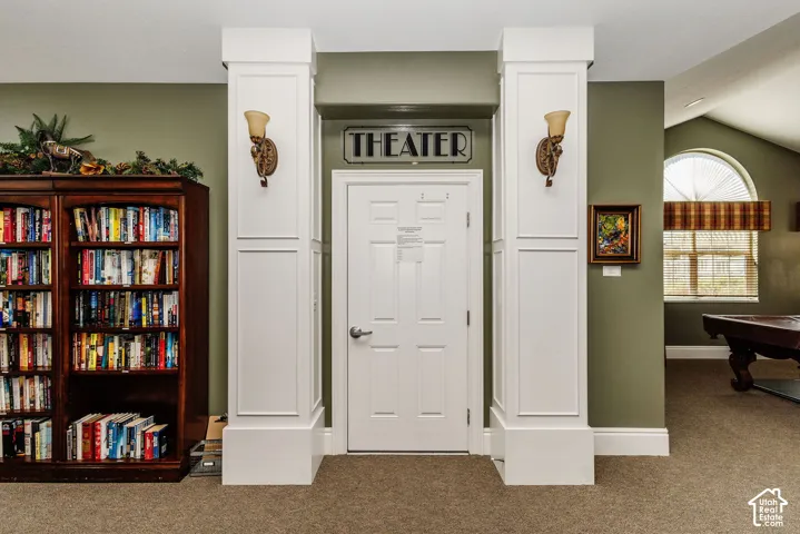 Theater entrance with decorative wall sconces and accent columns