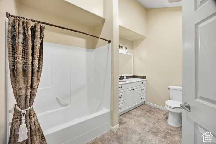 White vanity with cabinet storage, countertop, and an integrated sink