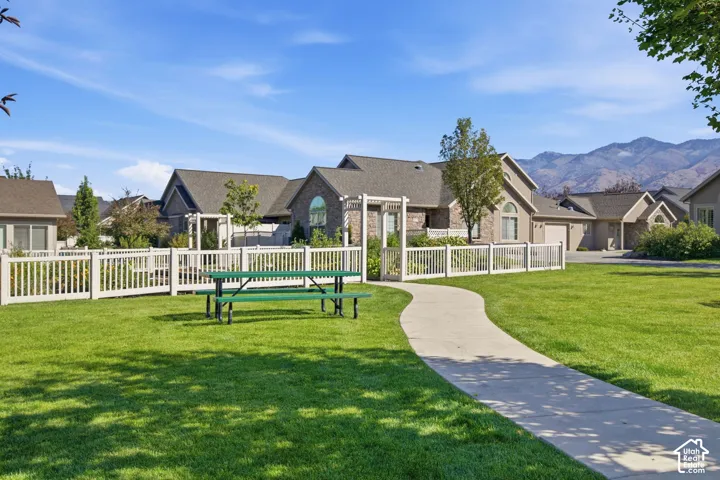 Expansive green space with a concrete pathway and white picket fencing