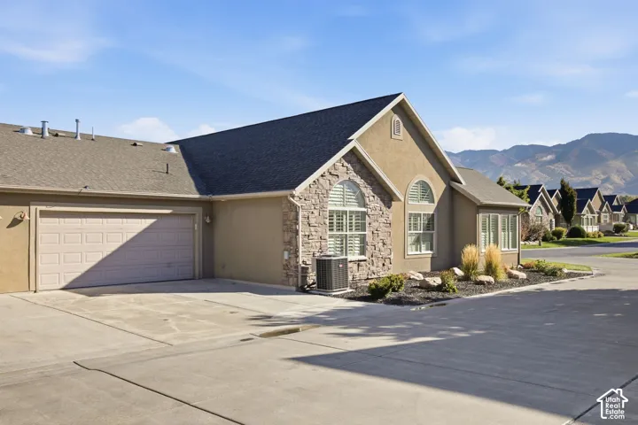 Stucco exterior with stone accents, arched windows, and a two-car garage