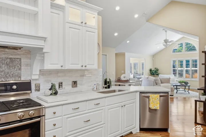 Kitchen featuring white cabinetry, stainless steel appliances, and a light-toned tile backsplash
