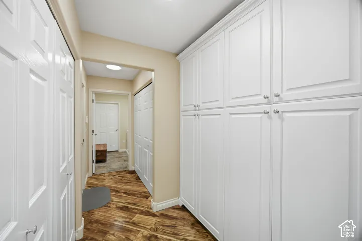 Built-in white paneled cabinetry, wood-finish flooring, recessed lighting, and crisp white doors