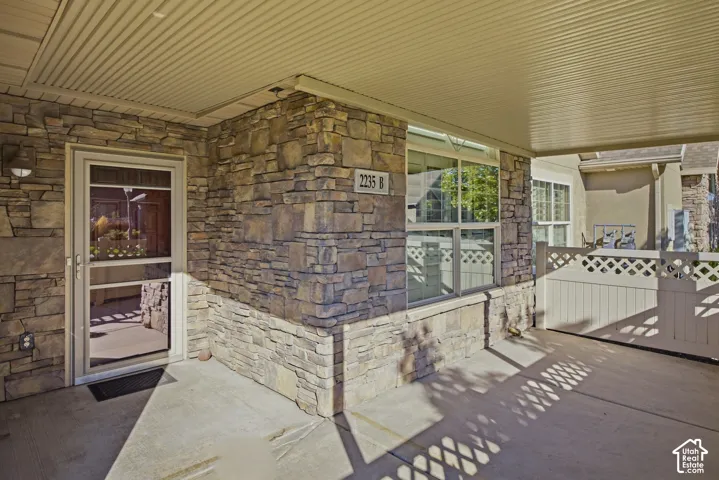 Stone veneer exterior with an integrated outdoor light fixture, a covered entry, and a large window