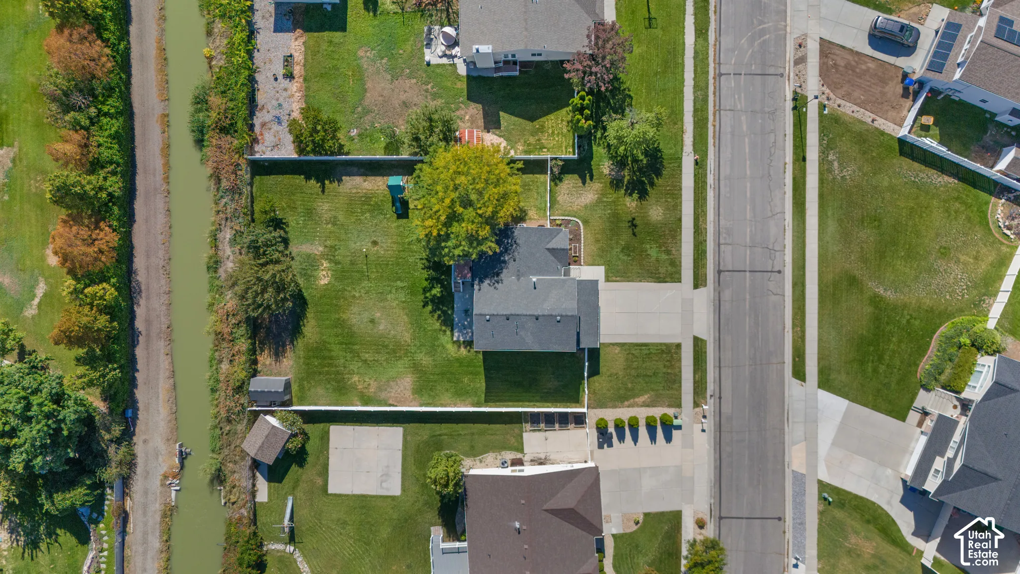 Expansive residential lot with a paved driveway and mature trees