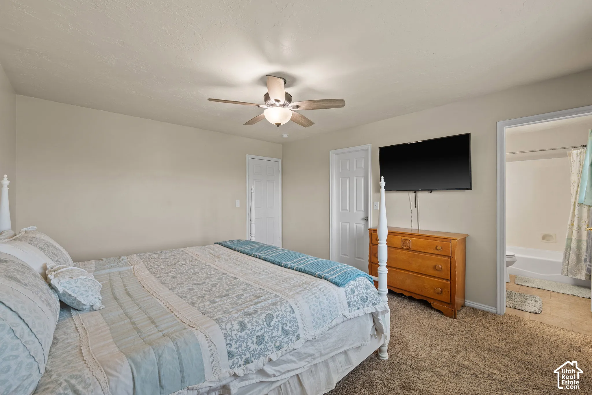 Spacious room with neutral wall tones and textured carpeting