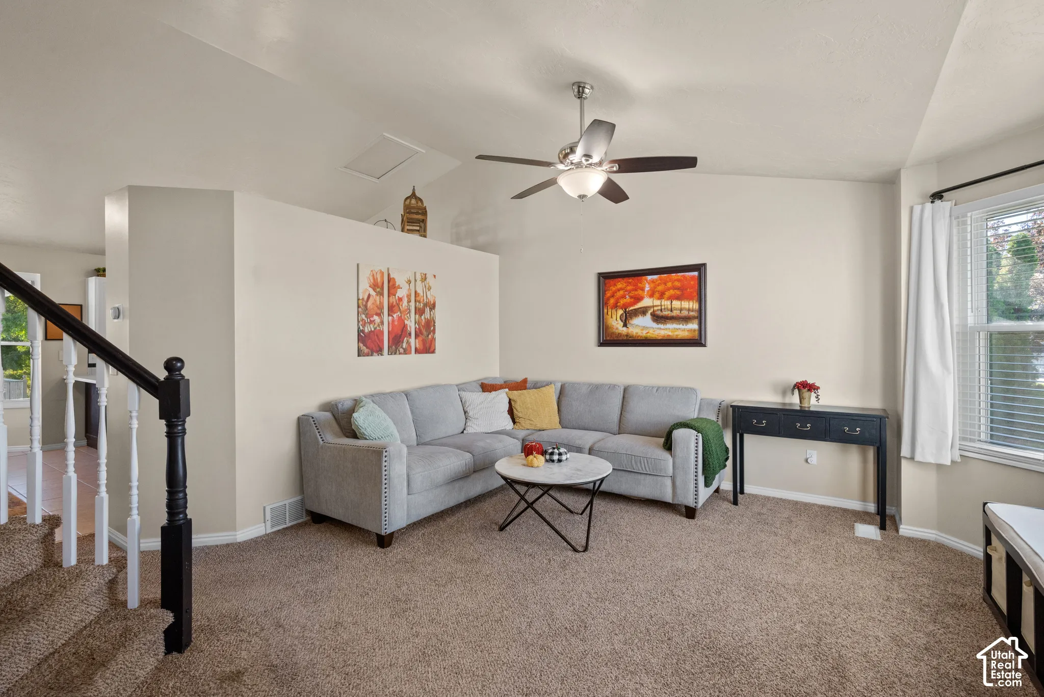 Vaulted ceiling with a ceiling fan, carpeted flooring, and a multi-pane window with blinds